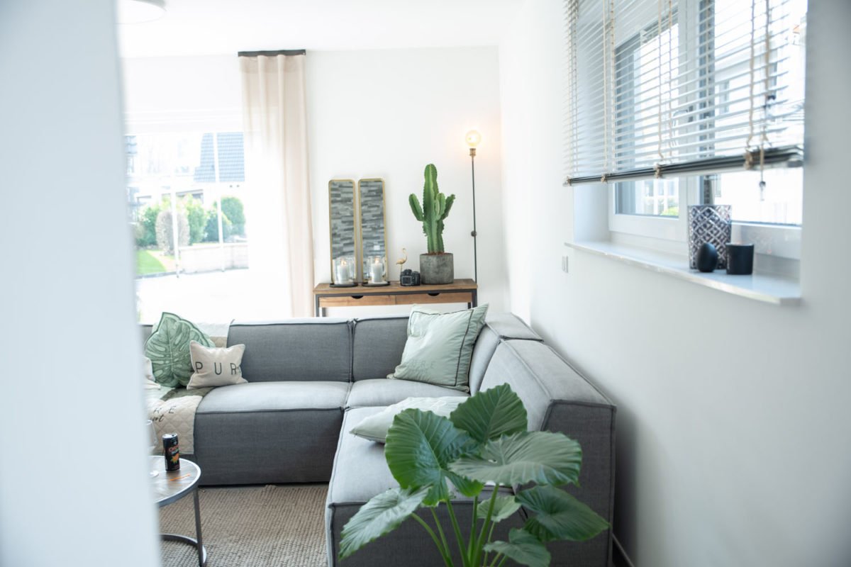 Musterhaus Flamingo - Ein Wohnzimmer mit Möbeln und einem großen Fenster - Interior Design Services