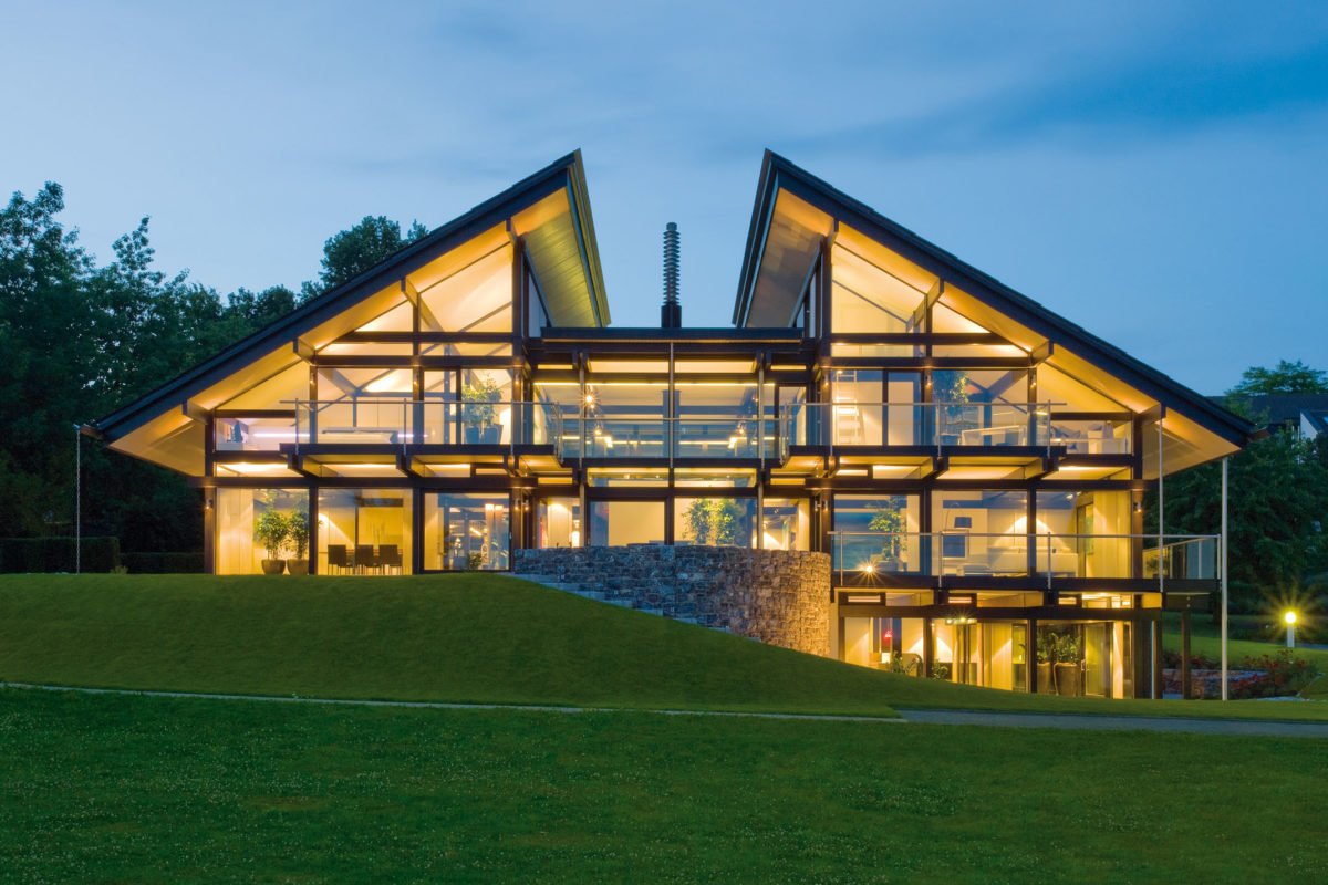 HUF HAUS Musterhaus Hartenfels - Ein großes Gebäude mit einer Uhr auf einer grasbewachsenen Wiese - Huf Haus