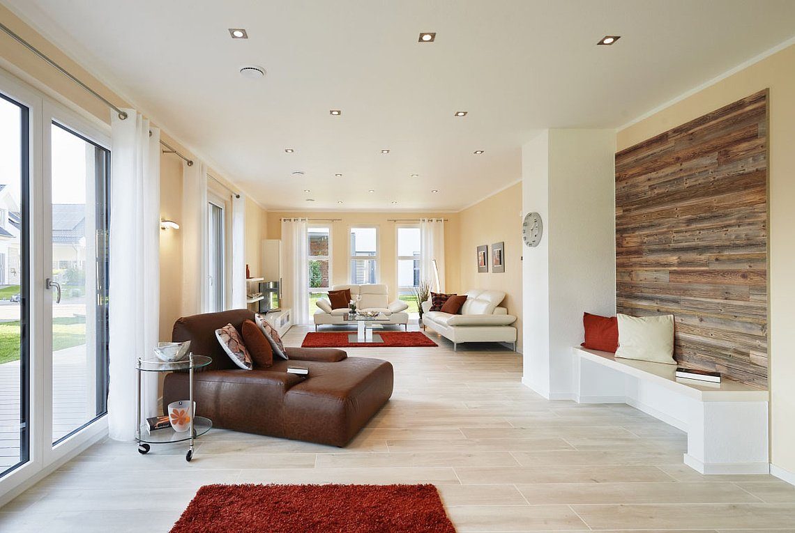 Musterhaus Oslo - Ein Wohnzimmer mit Möbeln und einem großen Fenster - Rensch-Haus GmbH