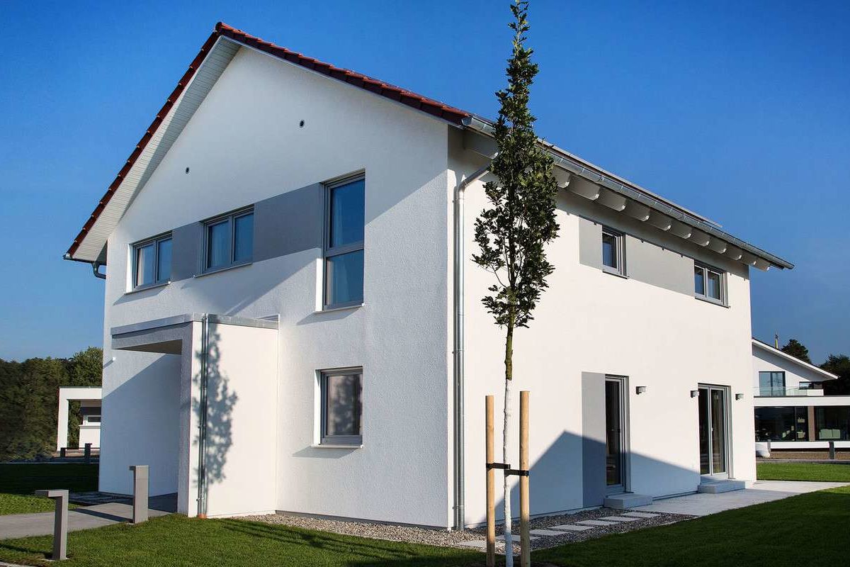 Musterhaus Günzburg - Ein Haus mit Bäumen im Hintergrund - Die Architektur