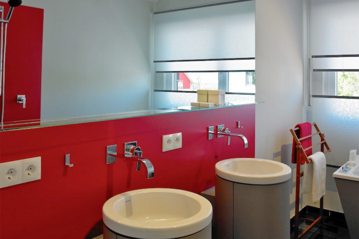Musterhaus Streif - Ein rot-weißes Waschbecken in einem Raum - Schiffscontainer-Architektur