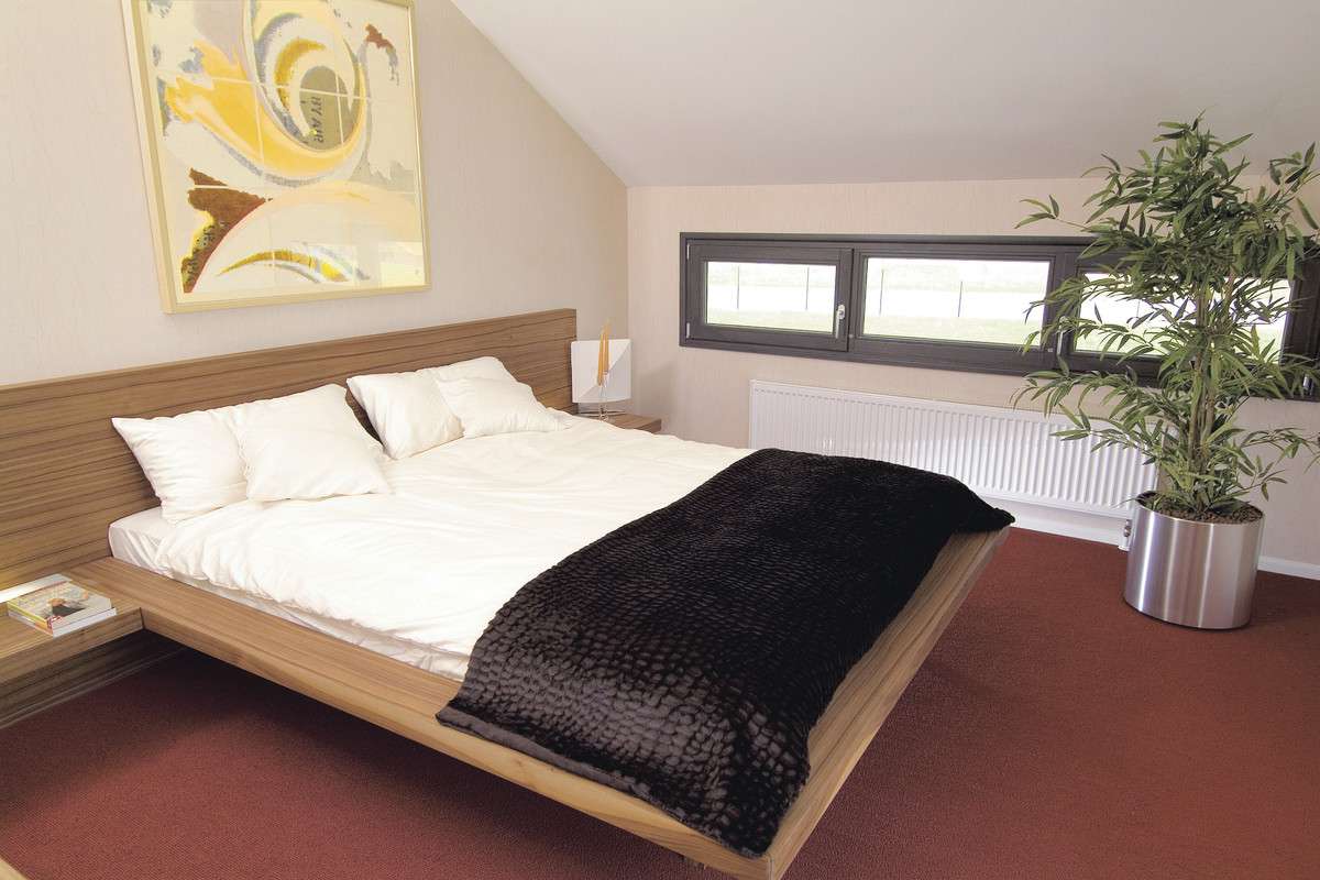 WeberHaus Dölzig - Ein Schlafzimmer mit einem Bett und einem Schreibtisch in einem Raum - WeberHaus
