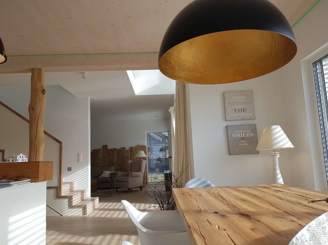 Musterhaus Köln - Ein Schlafzimmer mit einem Bett und einem Stuhl in einem Raum - Interior Design Services