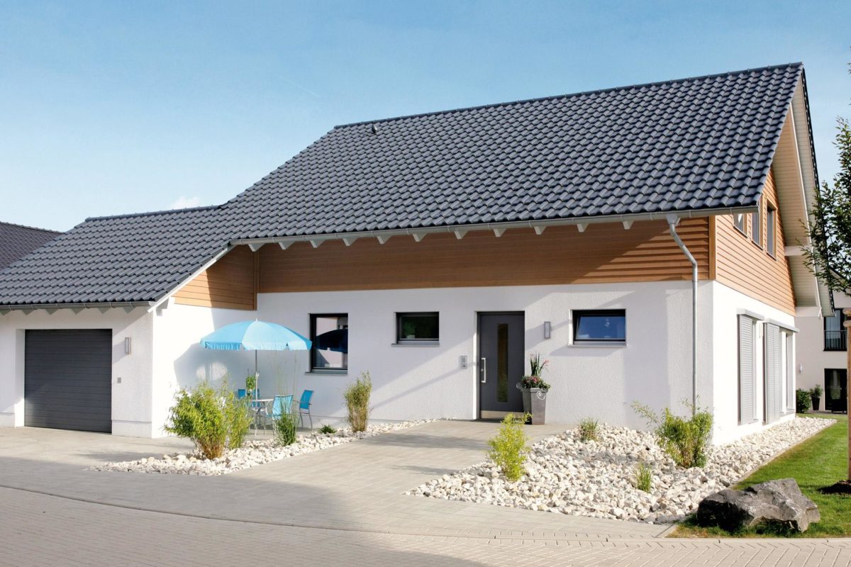 Musterhaus Hessdorf - Ein kleines haus auf einem parkplatz - Haus