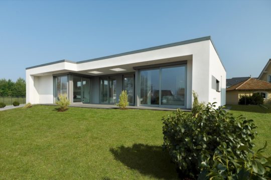 - Ein haus mit büschen vor einem gebäude - Haus zeigen