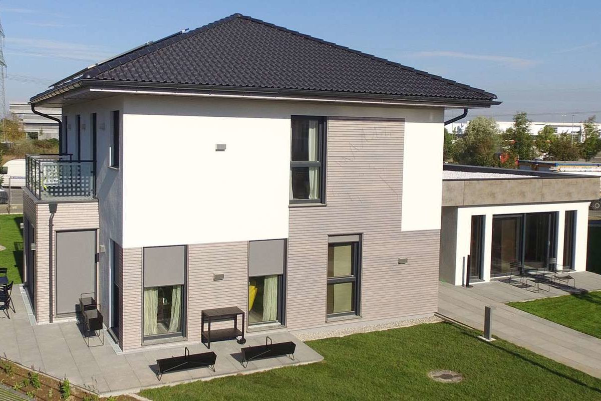 Automatisch gespeicherter Entwurf - Ein großes Backsteingebäude mit Gras vor einem Haus - ELK Fertighaus GmbH