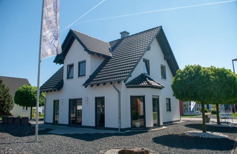 Automatisch gespeicherter Entwurf - Ein Baum vor einem Haus mit Amelia Earhart Birthplace im Hintergrund - Massivhaus Mittelrhein - Musterhaus Mülheim-Kärlich