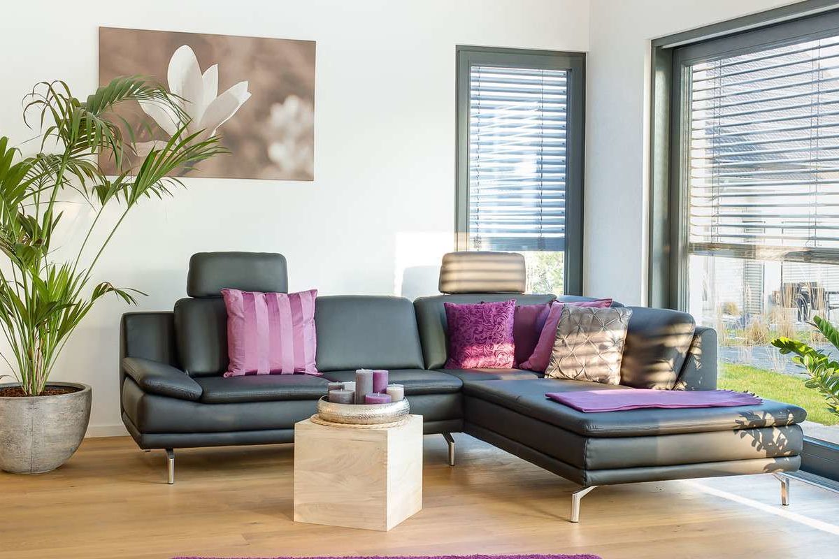 Musterhaus Wuppertal - Ein Wohnzimmer mit Möbeln und einem großen Fenster - Interior Design Services