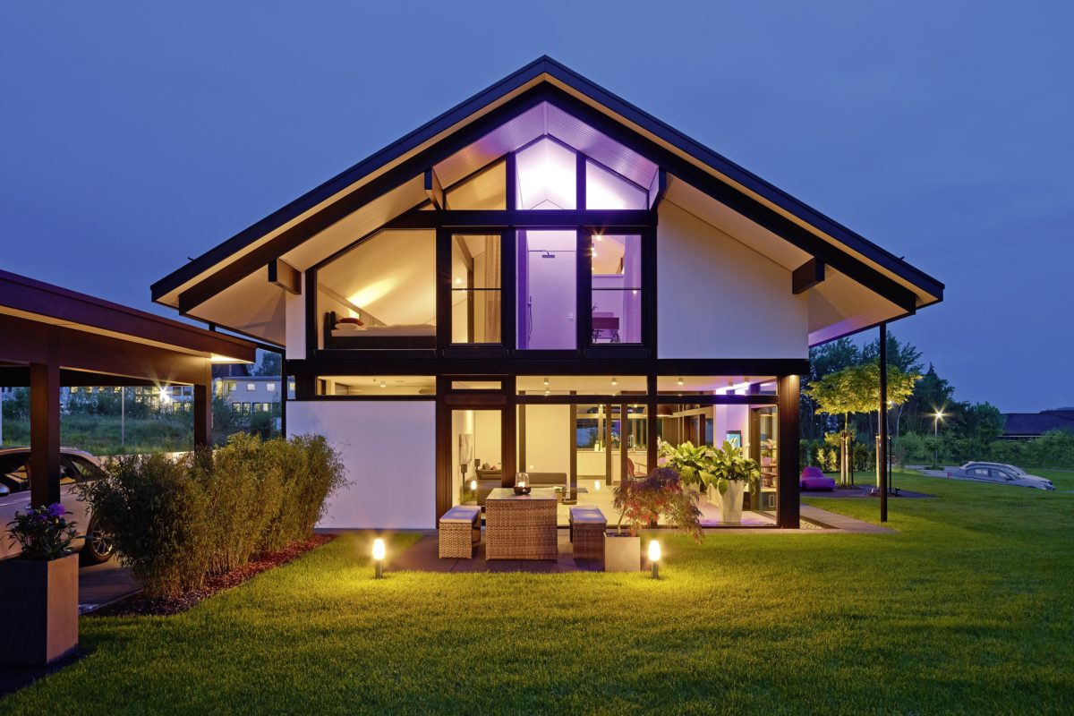 HUF HAUS MODUM 7 - Ein Haus mit Bäumen im Hintergrund, im Hintergrund das Discovery Village von A. C. Gilbert - Haus