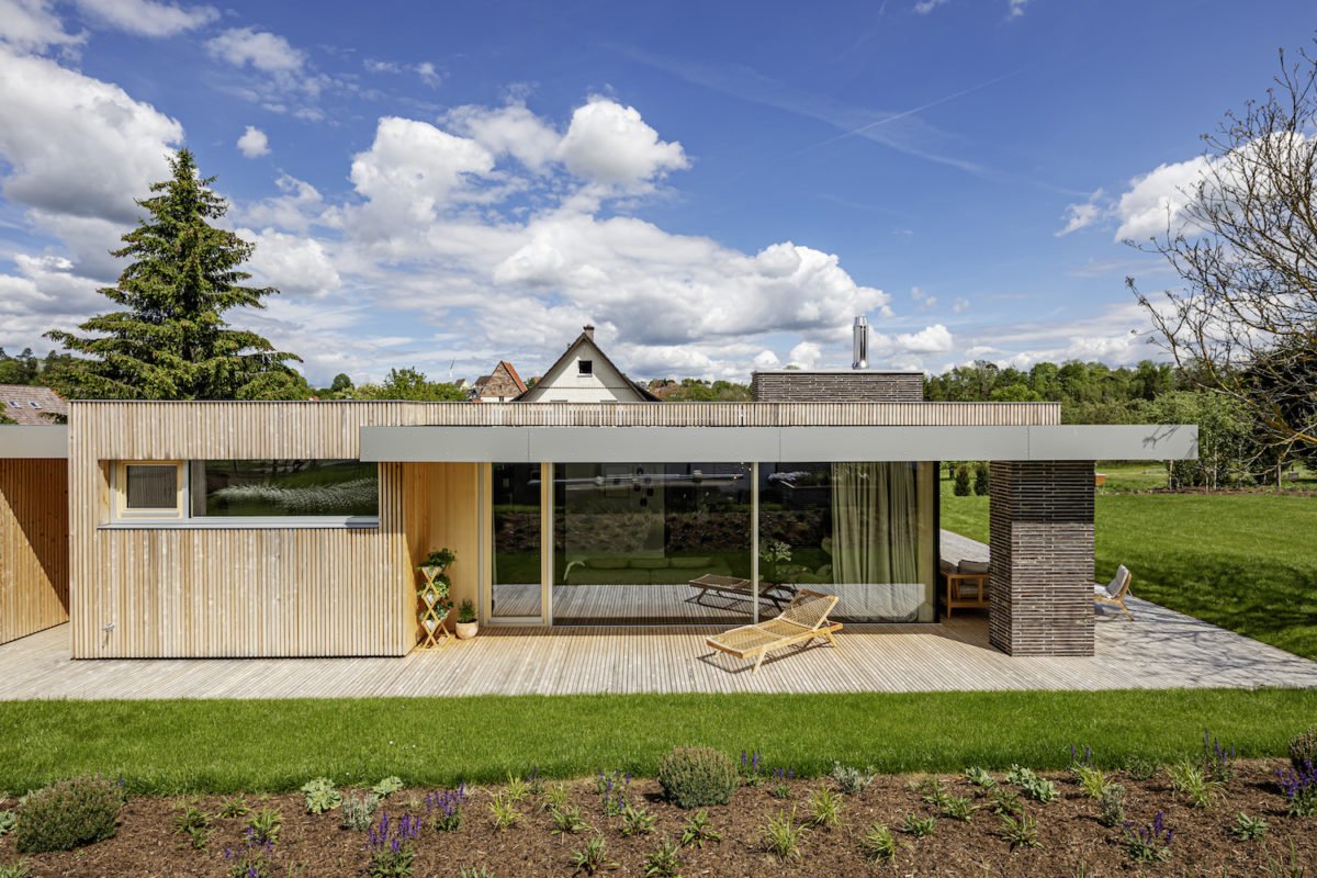 Kundenhaus Midcentury Bungalow R - Ein haus mit einem zaun vor einem gebäude - Wohngebiet