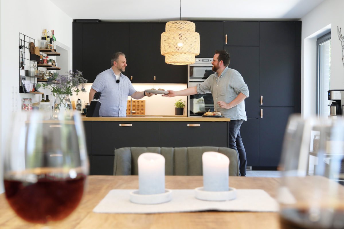 Kundenhaus Erlenbrunn - Ein Mann und eine Frau sitzen an einem Tisch mit Weingläsern - Interior Design Services