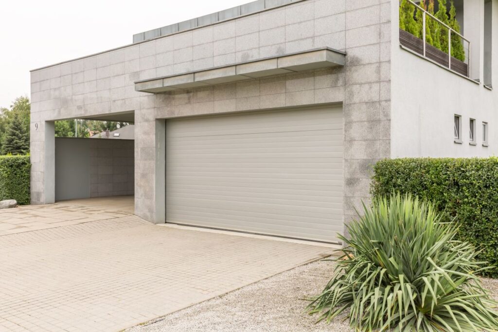 Garagenbau: Alles Wichtige von der Idee bis zur Fertigstellung Hausbau Helden Großes graues Haus mit Auffahrt und Parkhaus