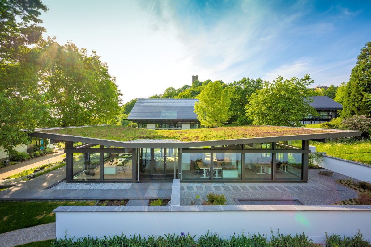 Musterhaus ART Bungalow - Ein bus, der auf einer bahnstrecke mit bäumen im hintergrund sitzt - Huf Haus