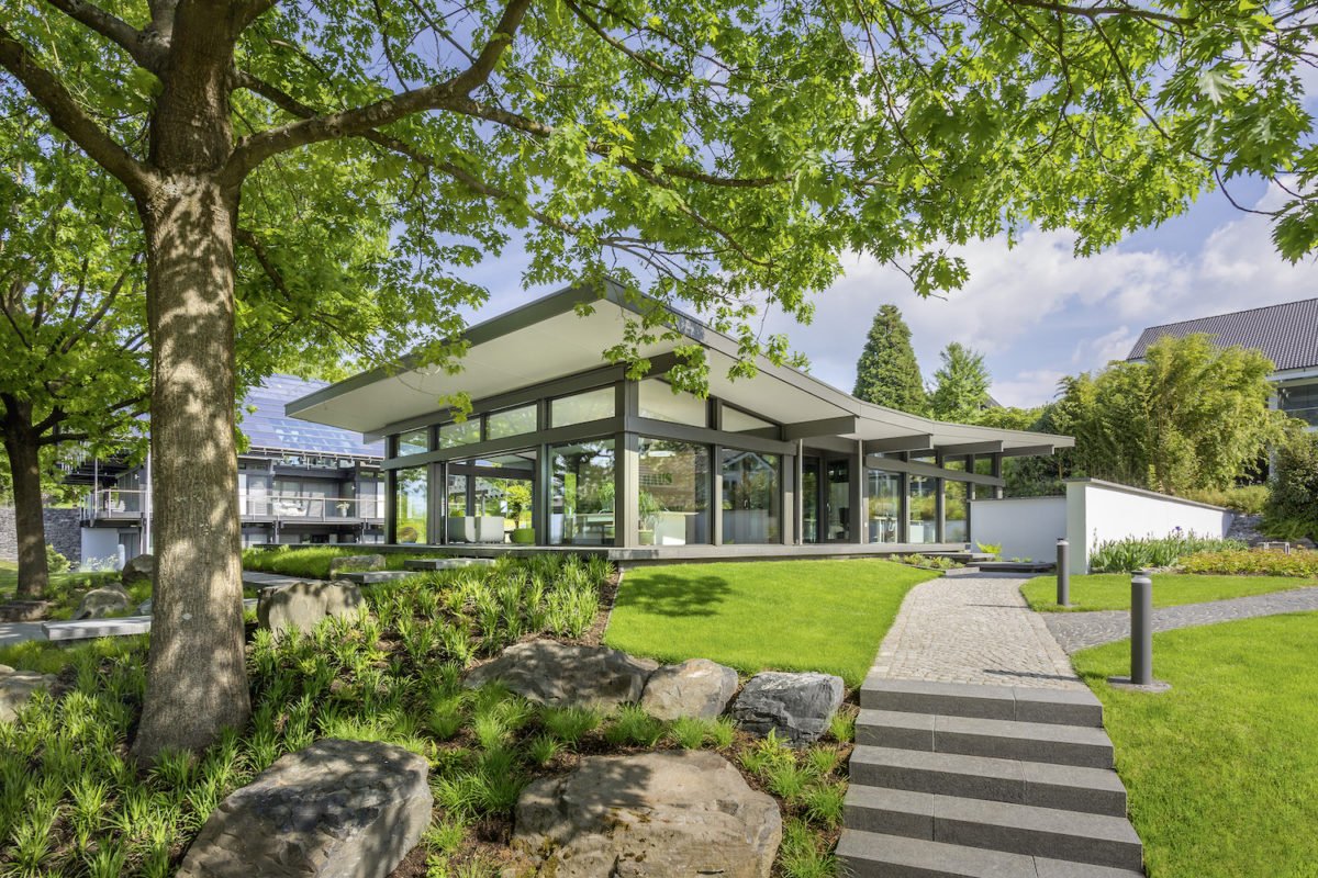 Musterhaus ART Bungalow - Eine große Wiese vor einem Haus - Huf Haus