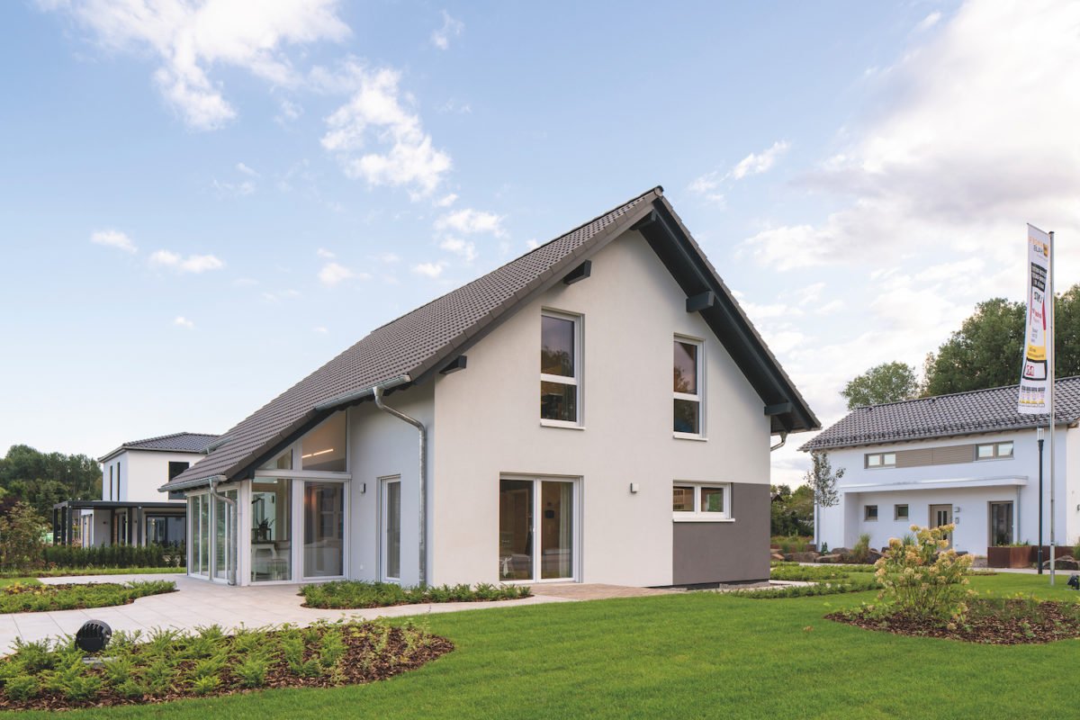 Musterhaus Juno - Eine große Wiese vor einem Haus - FingerHaus