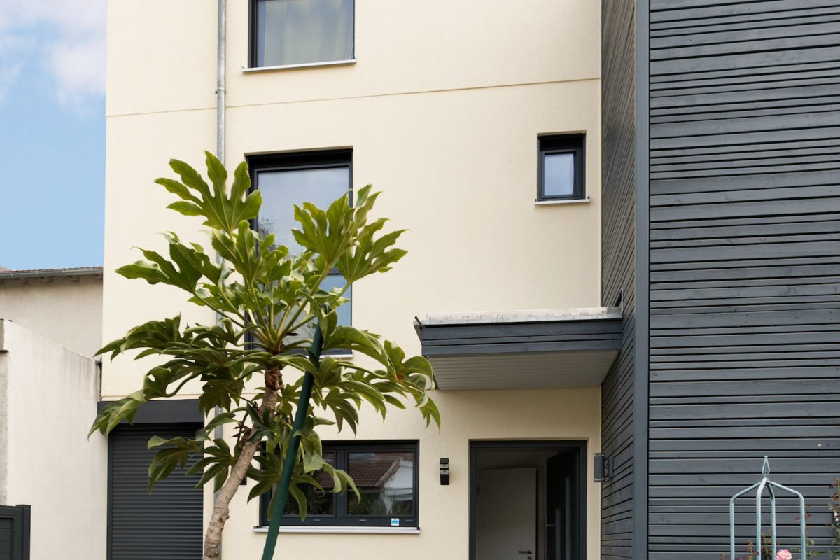Kundenhaus Oliveira - Ein Haus mit Bäumen vor einem Gebäude - Fassade