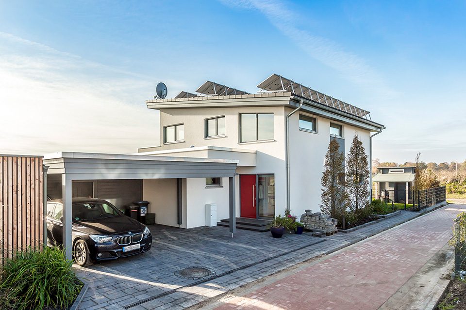 Frei stehendes Sonnen-Haus Außenansicht mit Carport