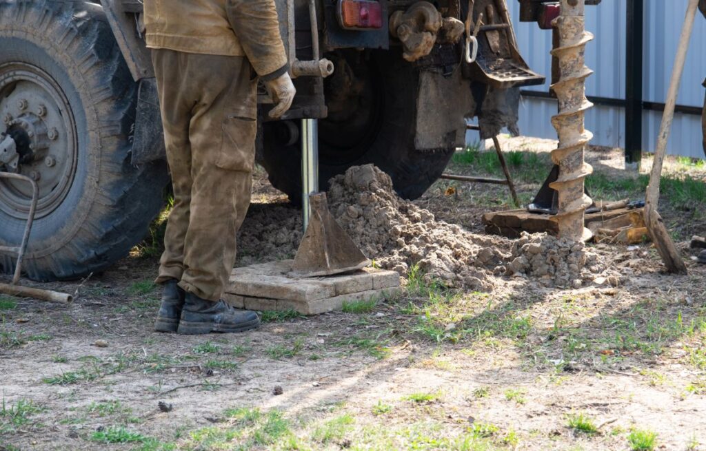 Wärmepumpe nachrüsten: Die wichtigsten Praxisschritte und Optionen im Portrait Hausbau Helden Ein Team von Arbeitern mit einer Bohranlage am Auto bohrt einen artesischen Brunnen für Wasser im Boden