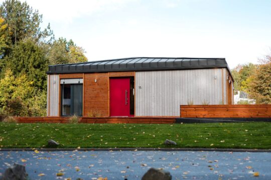 DWELLII Modulhaus TR 3 M Außenansicht Eingang mit roter Haustür