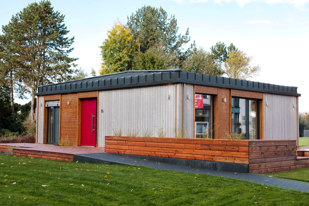 DWELLII Modulhaus TR 3 M Außenansicht Eingang seitlich mit roter Haustür
