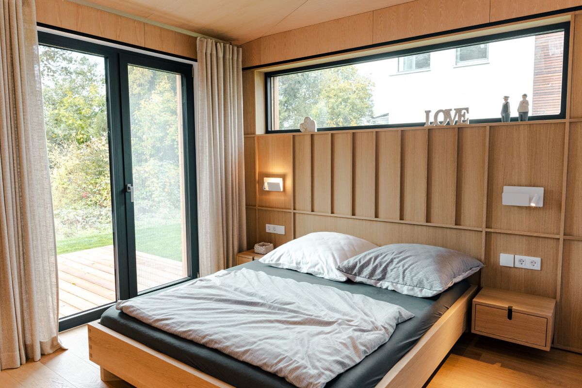 DWELLII Modulhaus TR 3 M Schlafzimmer mit viel Holz und Blick ins Freie