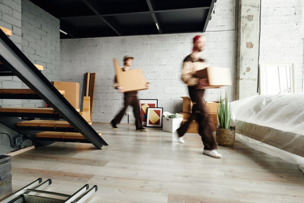 zwei Personen tragen Kisten beim Umzug